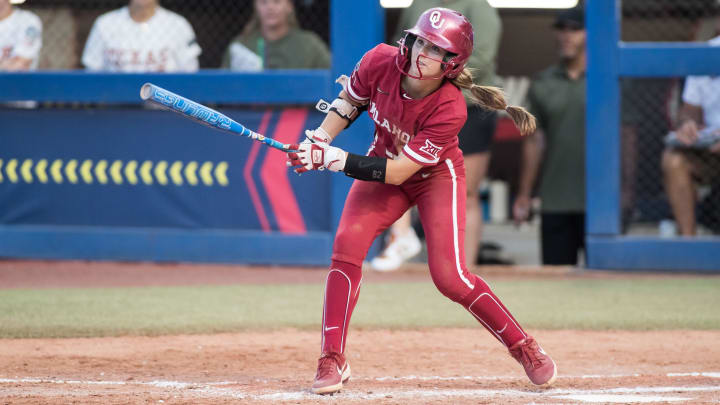 Jun 6, 2024; Oklahoma City, OK, USA;  Oklahoma Sooners infielder Avery Hodge (82) hits a single in the third inning against the Texas Longhorns during game two of the Women's College World Series softball championship finals at Devon Park. Mandatory Credit: Brett Rojo-USA TODAY Sports