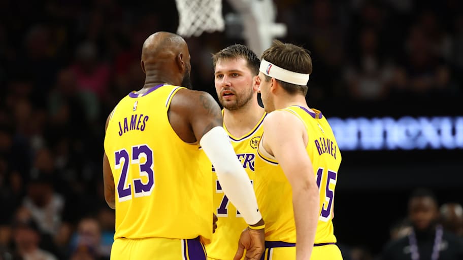 Los Angeles Lakers forward LeBron James huddles with guard Luka Dončić and guard Austin Reaves.