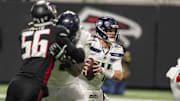 Dec 7, 2025; Atlanta, Georgia, USA; Seattle Seahawks quarterback Sam Darnold (14) tries to escape pressure against the Atlanta Falcons during the first quarter at Mercedes-Benz Stadium.