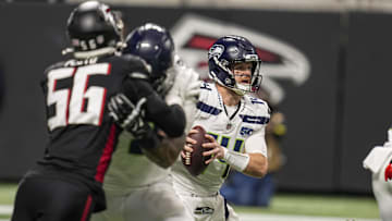 Dec 7, 2025; Atlanta, Georgia, USA; Seattle Seahawks quarterback Sam Darnold (14) tries to escape pressure against the Atlanta Falcons during the first quarter at Mercedes-Benz Stadium.