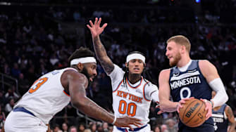 Oct 9, 2025; New York, New York, USA; Minnesota Timberwolves guard Donte Divincenzo tries to get past New York Knicks center/forward Mitchell Robinson (23) and guard Jordan Clarkson (00) during the first half at Madison Square Garden. Mandatory Credit: John Jones-Imagn Images