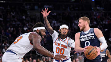 Oct 9, 2025; New York, New York, USA; Minnesota Timberwolves guard Donte Divincenzo tries to get past New York Knicks center/forward Mitchell Robinson (23) and guard Jordan Clarkson (00) during the first half at Madison Square Garden. Mandatory Credit: John Jones-Imagn Images
