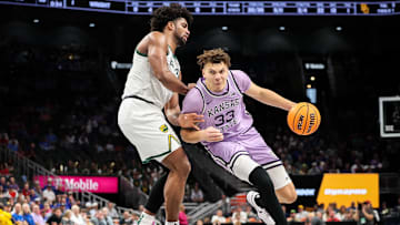 Mar 12, 2025; Kansas City, MO, USA; Kansas State Wildcats guard Coleman Hawkins (33) drives to the basket around Baylor Bears forward Norchad Omier (15) during the second half at T-Mobile Center. Mandatory Credit: William Purnell-Imagn Images