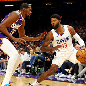 Apr 9, 2024; Phoenix, Arizona, USA;  LA Clippers forward Paul George (13) handles the ball against Phoenix Suns forward Kevin Durant (35) during the first quarter at Footprint Center. Mandatory Credit: Mark J. Rebilas-Imagn Images