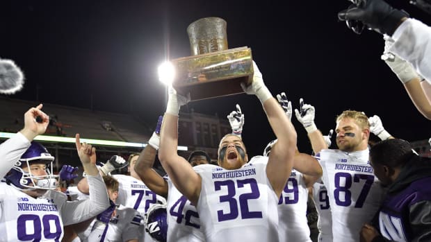 Northwestern Wildcats players hoist the Land of Lincoln Trophy after defeating the Illinois Fighting Illini.