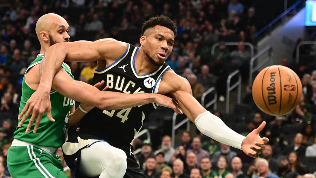 Milwaukee Bucks forward Giannis Antetokounmpo (34) and Boston Celtics guard Derrick White (9) reach for the ball.  