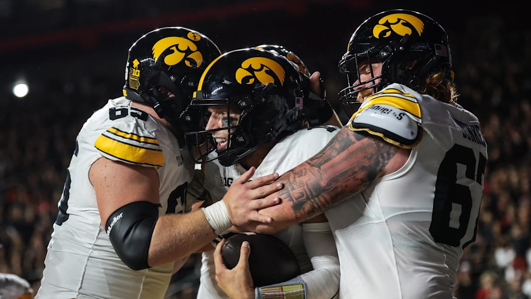 Sep 19, 2025; Piscataway, New Jersey, USA; Iowa Hawkeyes quarterback Mark Gronowski (11) celebrates with teammates after scoring a rushing touchdown during the first half against the Rutgers Scarlet Knights at SHI Stadium. Mandatory Credit: Vincent Carchietta-Imagn Images