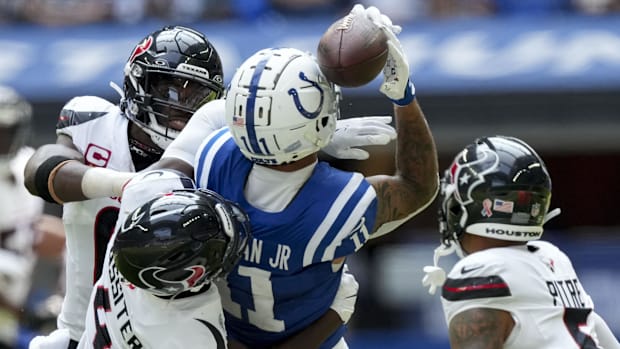 Colts receiver Michael Pittman Jr. (blue jersey; white trim) makes a tough catch around multiple defenders. 