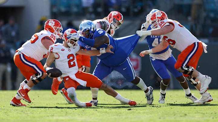 Dec 29, 2023; Jacksonville, FL, USA;  Clemson Tigers quarterback Cade Klubnik (2) is brought down by Kentucky Wildcats defensive lineman Deone Walker (0) in the third quarter during the Gator Bowl at EverBank Stadium. Mandatory Credit: Nathan Ray Seebeck-Imagn Images