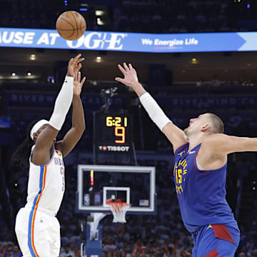 May 13, 2025; Oklahoma City, Oklahoma, USA; Oklahoma City Thunder guard Luguentz Dort (5) shoots a three point basket as Denver Nuggets center Nikola Jokic (15) defends during the second half of game five of the second round for the 2025 NBA Playoffs at Paycom Center. Mandatory Credit: Alonzo Adams-Imagn Images