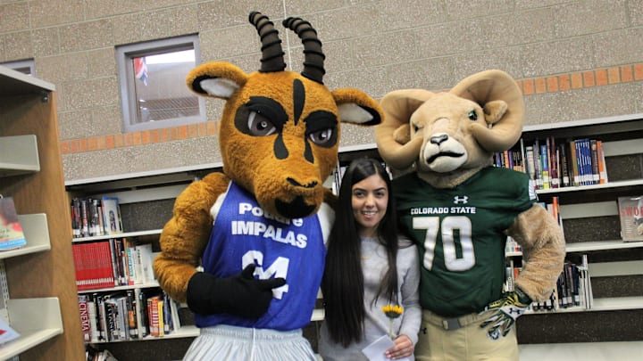 Cache the Impala (Poudre HS) and Cam the Ram (Colorado State) pose with a student in 2019.