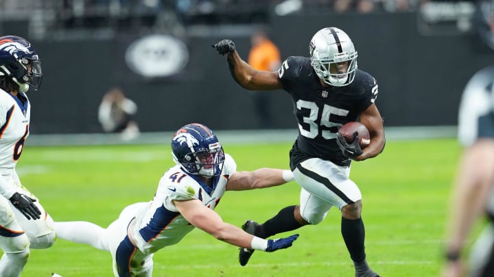 Jan 7, 2024; Paradise, Nevada, USA; Las Vegas Raiders running back Zamir White (35) is pushed out of bounds by Denver Broncos linebacker Drew Sanders (41) during the second quarter at Allegiant Stadium. Mandatory Credit: Stephen R. Sylvanie-USA TODAY Sports