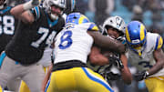 Nov 30, 2025; Charlotte, North Carolina, USA;  Carolina Panthers running back Chuba Hubbard (30) rushes as Los Angeles Rams linebacker Jared Verse (8) defends during the third quarter at Bank of America Stadium. Mandatory Credit: Scott Kinser-Imagn Images