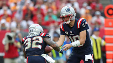 Nov 9, 2025; Tampa, Florida, USA; New England Patriots quarterback Drake Maye (10) hands the ball off to running back Treveyon Henderson (32) during the fourth quarter against the Tampa Bay Buccaneers at Raymond James Stadium. Mandatory Credit: Nathan Ray Seebeck-Imagn Images