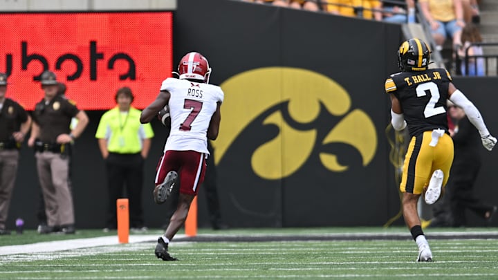 Sep 14, 2024; Iowa City, Iowa, USA; Troy Trojans wide receiver Devonte Ross (7) catches a 63 yard touchdown pass from quarterback Matthew Caldwell (not pictured) as Iowa Hawkeyes defensive back TJ Hall (2) pursues during the second quarter at Kinnick Stadium. Mandatory Credit: Jeffrey Becker-Imagn Images