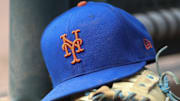 Jul 13, 2022; Atlanta, Georgia, USA; A detailed view of a New York Mets hat and glove in the dugout against the Atlanta Braves in the eighth inning at Truist Park. 