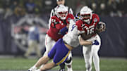 Dec 28, 2024; Annapolis, MD, USA;  East Carolina Pirates defensive lineman J.D. Lampley (9) sacks North Carolina State Wolfpack quarterback CJ Bailey (16) during the first half of the Go Bowling Military Bowl at Navy-Marine Corps Memorial Stadium. Mandatory Credit: Tommy Gilligan-Imagn Images