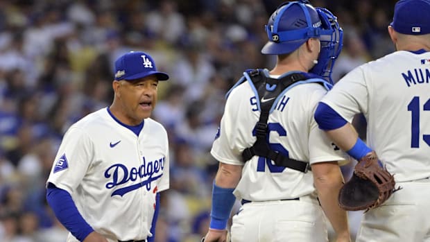 Dodgers manager Dave Roberts (30) meets on the mound