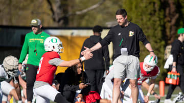 Oregon head coach Dan Lanning greets quarterback Dillon Gabriel during practice with the Oregon Ducks Tuesday, April 2, 2024 in Eugene, Ore.