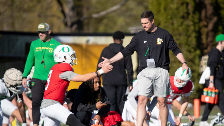 Oregon head coach Dan Lanning greets quarterback Dillon Gabriel during practice with the Oregon Ducks Tuesday, April 2, 2024 in Eugene, Ore.