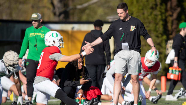 Oregon head coach Dan Lanning greets quarterback Dillon Gabriel during practice.