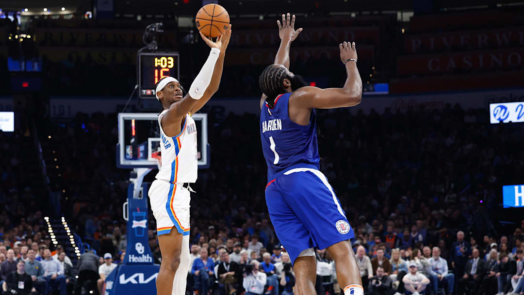 Dec 21, 2023; Oklahoma City, Oklahoma, USA; Oklahoma City Thunder guard Shai Gilgeous-Alexander (2) shoots a three-point basket as LA Clippers guard James Harden (1) defends during the second quarter at Paycom Center. Mandatory Credit: Alonzo Adams-Imagn Images