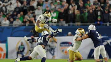 Jan 9, 2025; Miami, FL, USA; (Editors Note: Caption Correction) Notre Dame Fighting Irish running back Jeremiyah Love (4) leaps over Penn State Nittany Lions linebacker Kobe King (41) in the second half in the Orange Bowl at Hard Rock Stadium. Mandatory Credit: Sam Navarro-Imagn Images