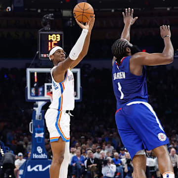 Dec 21, 2023; Oklahoma City, Oklahoma, USA; Oklahoma City Thunder guard Shai Gilgeous-Alexander (2) shoots a three-point basket as LA Clippers guard James Harden (1) defends during the second quarter at Paycom Center. Mandatory Credit: Alonzo Adams-Imagn Images