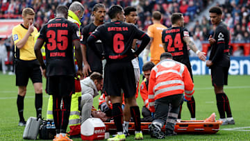 Die Profis von Bayer Leverkusen mit sorgenvoller Mine: Mitspieler Alejandro Grimaldo verletzt am Boden