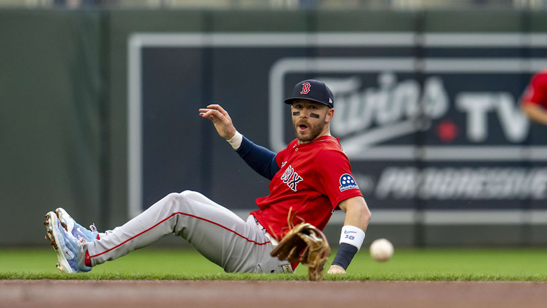 Apr 13, 2026; Minneapolis, Minnesota, USA; Boston Red Sox shortstop Trevor Story (10) looks on as he looses his glove attempting to field a ground ball against the Minnesota Twins in the first inning at Target Field. Mandatory Credit: Jesse Johnson-Imagn Images