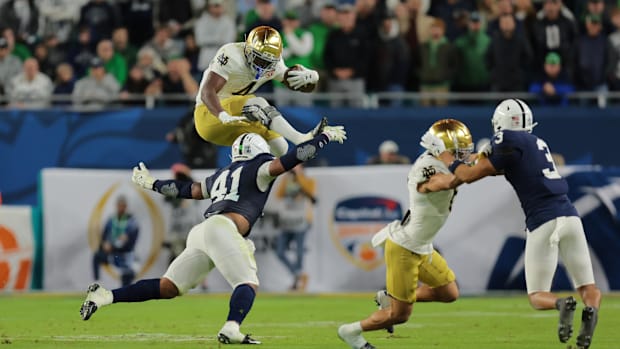 Notre Dame running back Jeremiyah Love hurdles a Penn State defender.
