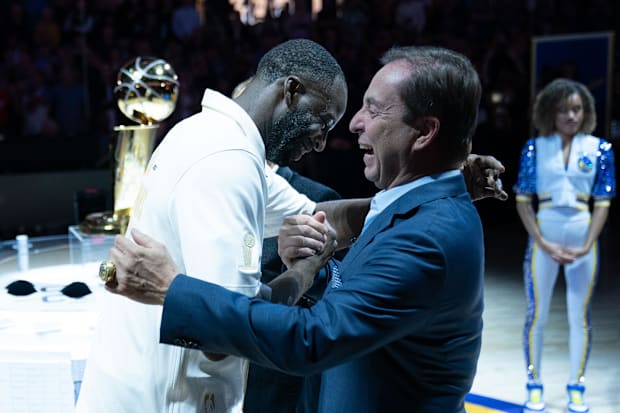 Golden State Warriors forward Draymond Green (23) hugs owner Joe Lacob (right)