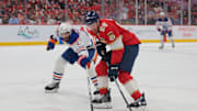 Jun 12, 2025; Sunrise, Florida, USA; Edmonton Oilers defenseman Evan Bouchard (2) reaches for the puck defending against Florida Panthers defenseman Nate Schmidt (88) during the second period in game four of the 2025 Stanley Cup Final at Amerant Bank Arena. 