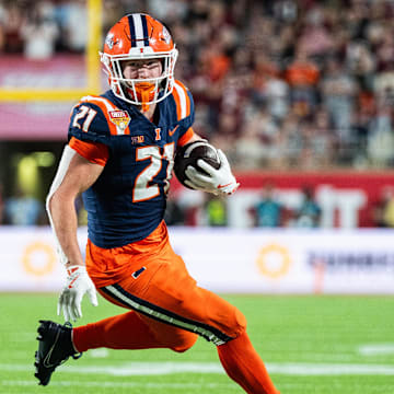 Dec 31, 2024; Orlando, FL, USA; Illinois Fighting Illini running back Aidan Laughery (21) runs the ball against South Carolina Gamecocks linebacker Debo Williams (0) in the fourth quarter at Camping World Stadium. Mandatory Credit: Jeremy Reper-Imagn Images