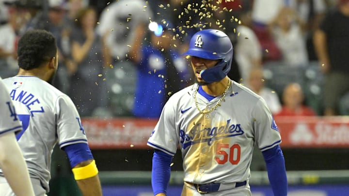 Sep 3, 2024; Anaheim, California, USA;  Los Angeles Dodgers shortstop Mookie Betts (50) is showered with seeds by left fielder Teoscar Hernandez (37) after hitting a three-run home run in the tenth inning against the Los Angeles Angels at Angel Stadium. Mandatory Credit: Jayne Kamin-Oncea-Imagn Images