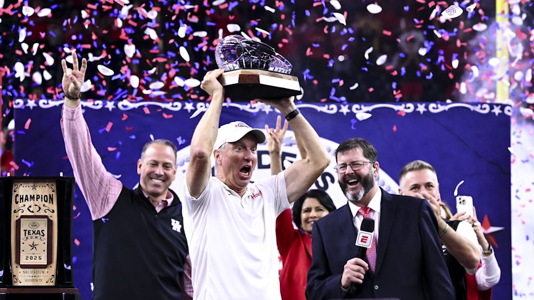 Houston Cougars head coach Willie Fritz hoists the Texas Bowl trophy after the win over Louisiana State Tigers at NRG Stadium. Mandatory Credit: Maria Lysaker-Imagn Images 