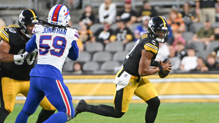 Aug 17, 2024; Pittsburgh, Pennsylvania, USA;  Pittsburgh Steelers quarterback Justin Fields (2) runs away from Buffalo Bills defensive end Kingsley Jonathan (59) during the second quarter at Acrisure Stadium. Mandatory Credit: Barry Reeger-USA TODAY Sports