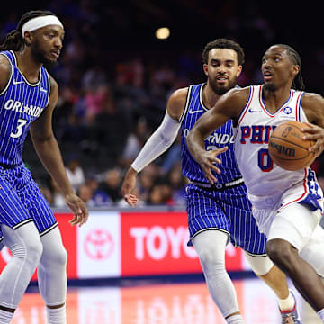 Oct 10, 2025; Philadelphia, Pennsylvania, USA; Philadelphia 76ers guard Tyrese Maxey (0) drives past Orlando Magic guard Tyus Jones (2) during the first quarter at Xfinity Mobile Arena. Mandatory Credit: Bill Streicher-Imagn Images