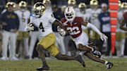 Nov 29, 2025; Stanford, California, USA;  Notre Dame Fighting Irish running back Jeremiyah Love (4) runs with the football during the first quarter against Stanford Cardinal safety Che Ojarikre (22) at Stanford Stadium. 