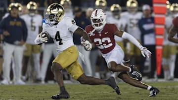 Nov 29, 2025; Stanford, California, USA;  Notre Dame Fighting Irish running back Jeremiyah Love (4) runs with the football during the first quarter against Stanford Cardinal safety Che Ojarikre (22) at Stanford Stadium. 