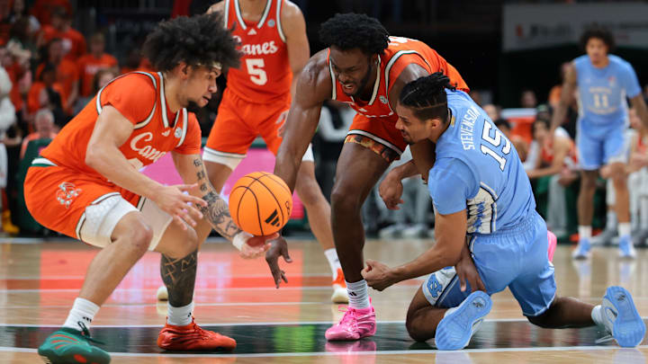 Feb 10, 2026; Coral Gables, Florida, USA; Miami Hurricanes center Ernest Udeh Jr. (8) and North Carolina Tar Heels forward Jarin Stevenson (15) battle for a loose ball during the first half at Watsco Center. Mandatory Credit: Sam Navarro-Imagn Images