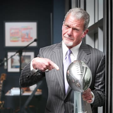 Late Indianapolis Colts owner and CEO Jim Irsay holds the 2006 Super Bowl XLI trophy in his office.