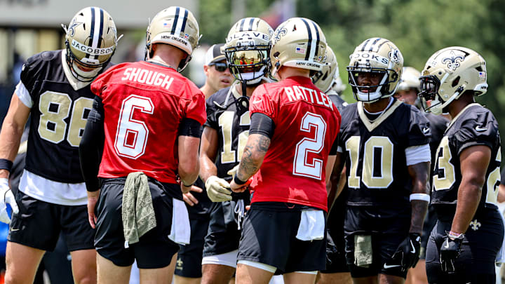 Tyler Shough and Spencer Rattler lead a huddle during New Orleans Saints Mandatory Minicamp