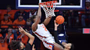 Dec 29, 2024; Champaign, Illinois, USA;  Illinois Fighting Illini forward Morez Johnson Jr. (21) dunks the ball over Chicago State Cougars forward CJ Delancy (20) and Noble Crawford (11) during the second half at State Farm Center. Mandatory Credit: Ron Johnson-Imagn Images