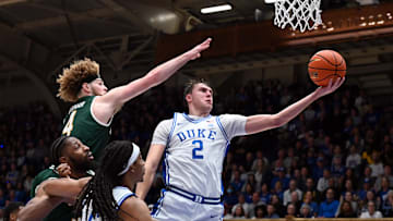 Dec 17, 2024; Durham, North Carolina, USA;  Duke basketball forward Cooper Flagg (2) lays the ball up in front of George Mason Patriots guard Brayden O'Connor (4) during the second half at Cameron Indoor Stadium. 