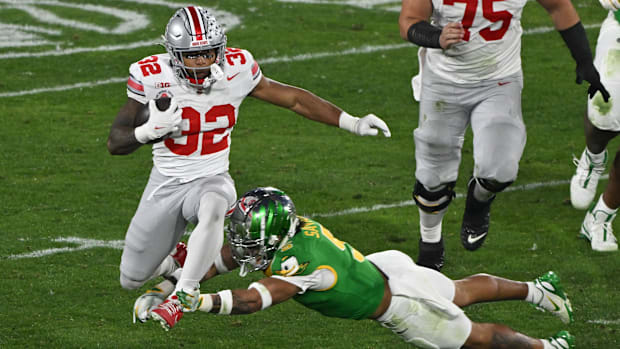 Ohio State Buckeyes running back TreVeyon Henderson (32) leaps over Oregon Ducks defensive back Kobe Savage (5)