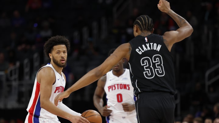 Mar 7, 2024; Detroit, Michigan, USA;  Detroit Pistons guard Cade Cunningham (2) dribbles defended by Brooklyn Nets center Nic Claxton (33) in the first half at Little Caesars Arena. Mandatory Credit: Rick Osentoski-USA TODAY Sports