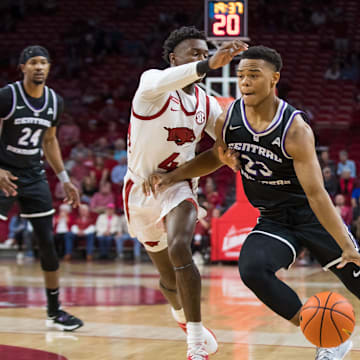 Dec 1, 2021; Fayetteville, Arkansas, USA;  Central Arkansas Bears guard Camren Hunter (23) drives around Arkansas Razorbacks guard Davonte Davis (4) during the first half at Bud Walton Arena. Mandatory Credit: Brett Rojo-Imagn Images