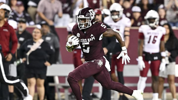 Nov 16, 2024; College Station, Texas, USA; Texas A&M Aggies running back Amari Daniels (5) runs the ball during the first half against the New Mexico State Aggies at Kyle Field. Mandatory Credit: Maria Lysaker-Imagn Images 