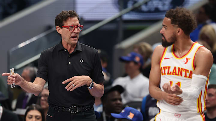 Atlanta Hawks head coach Quin Snyder speaks with Trae Young #11 during a game against the Dallas Mavericks.